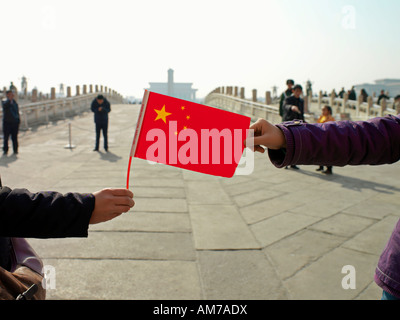 A visitor to the Forbidden City in Beijing China holds a Chinese flag. Stock Photo