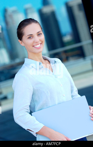 Businesswoman holding files, smiling, side view Stock Photo
