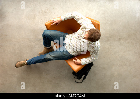 Man relaxing on chair, overhead view Stock Photo
