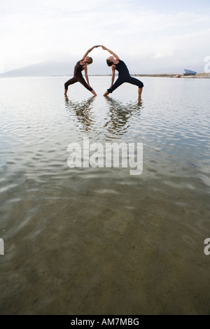 two woman practise couple yoga in nature Stock Photo