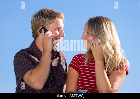 A young couple, both with their mobile phones Stock Photo