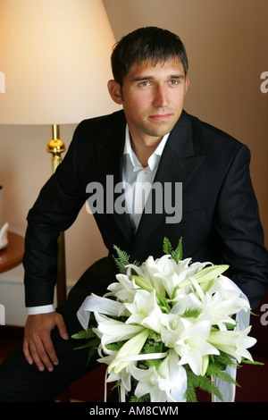 Handsome Groom holding a bouquet of flowers Stock Photo