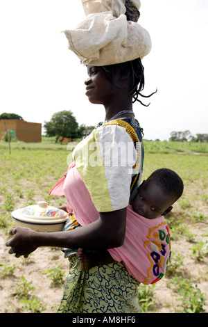 Fada N Gourma Burkina Faso August 23rd 2005 An Oue mother with her baby in a sling on her back Stock Photo