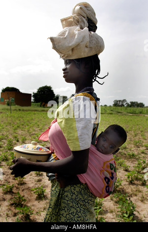 Fada N Gourma Burkina Faso August 23rd 2005 An Oue mother with her baby in a sling on her back Stock Photo