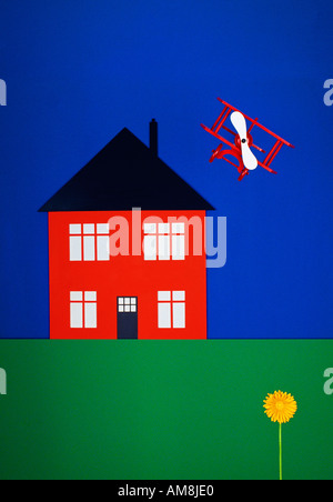 red cut out toy house on green grass with toy biplane and yellow flower Stock Photo