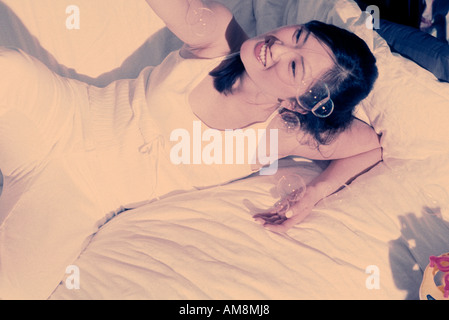 Young woman lying on bed Stock Photo