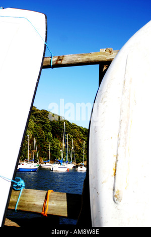Dinghy s resting along the harbour railing with sailing boats in the ...