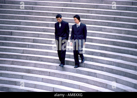 Two Businessmen Walking Down Stairs Stock Photo