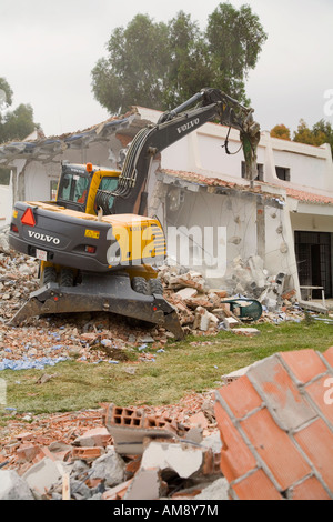 Demolition of old buildings with aid of mechanical excavator Stock Photo