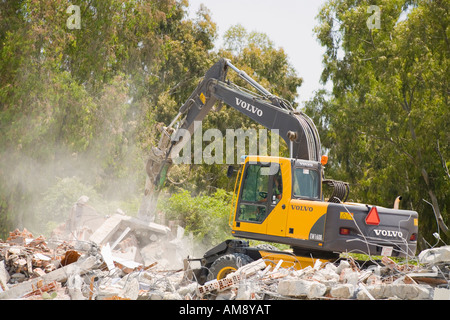 Demolition of old buildings with aid of mechanical excavator Stock Photo