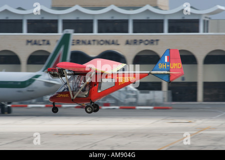 Thruster T-600N microlight aircraft flying at low level over the runway at Malta International Airport Stock Photo