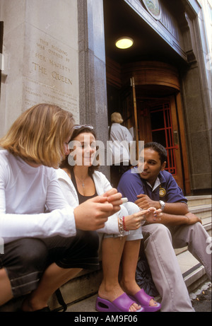 Group of students at further education college chatting on steps. Stock Photo