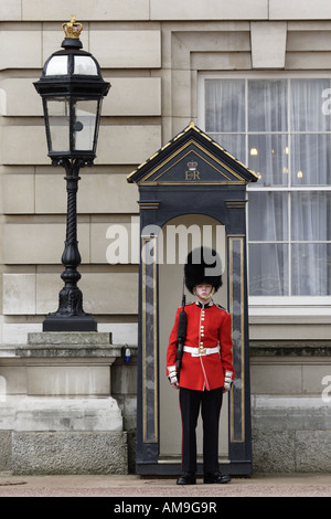 A member of the Scots Guards stands watch in the forecourt of Buckingham Palace, London. Stock Photo