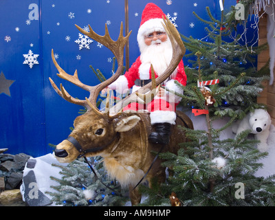 Santa's Grotto display in British garden centre where Santa is sitting on a sleigh being pulled by reindeer Stock Photo