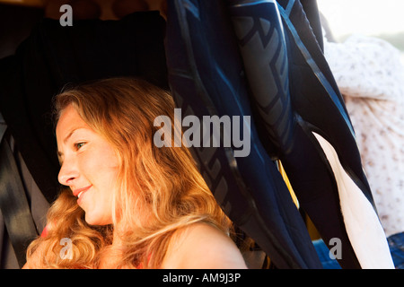 Woman in a van with wetsuit smiling. Stock Photo