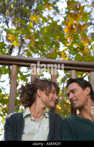 Couple outdoors on balcony sitting together and smiling. Stock Photo