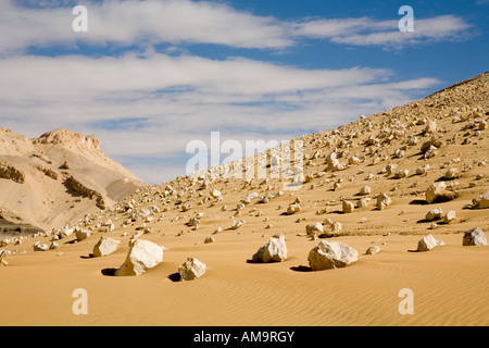 Boulder field on hill side reaching to sandy desert floor, near Dakhla Oasis, Egypt , North Africa Stock Photo