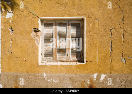 Old wooden framed window with shutters  in painted mud brick wall in Egypt, North Africa Stock Photo