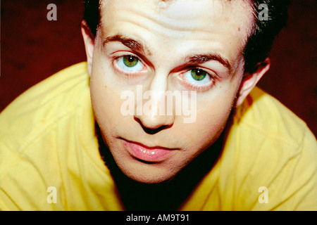 Closeup Portrait of a Young Man He is Making Eye Contact With Camera Lens and has a Serious Expression on his Face Stock Photo