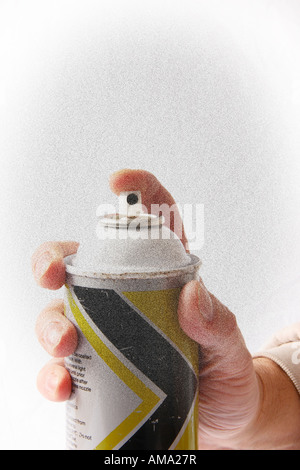 Hand holding an aerosol spray can and spraying at camera. Stock Photo