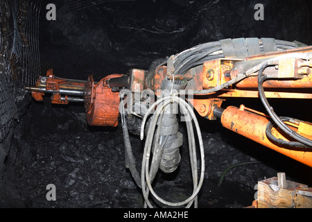 Jumbo mining equipment at stope face placing rock bolts and mesh for ...