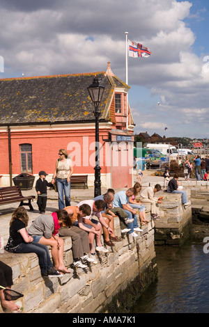 UK Dorset Poole Old Town families fishing for crabs from the quayside near the old lifeboat station Stock Photo