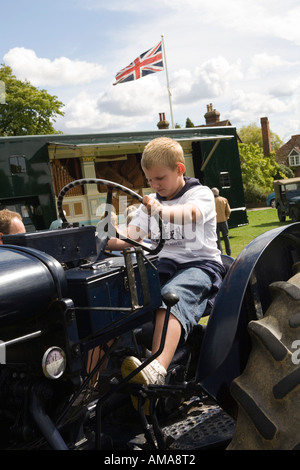 West Sussex Wisborough Green Village Fair on the Green boy sat on old tractor Stock Photo