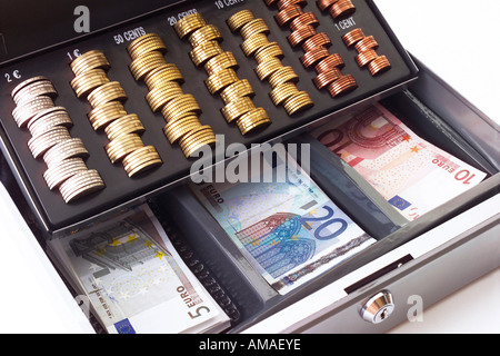 Cash box filled with coins and banknotes, elevated view, close-up Stock Photo