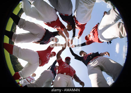 A baseball team with their hands stacked together in a huddle Stock Photo