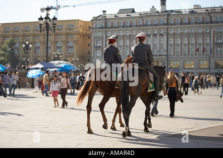 TWO MOUNTED POLICE OFFICERS RIDING HORSES THROUGH CROWDS IN MANEZHNAYA SQUARE MOSCOW RUSSIA Stock Photo