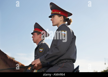 TWO MOUNTED POLICE OFFICERS RIDING HORSES THROUGH CROWDS IM MANEZHNAYA SQUARE MOSCOW RUSSIA Stock Photo