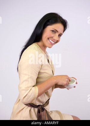 Woman holding mortar and pestle, smiling, portrait Stock Photo