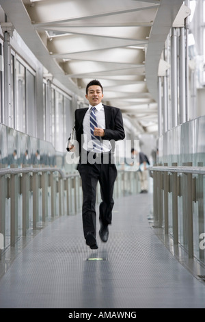 A businessman running along a corridor Stock Photo