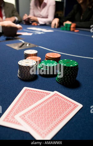 Playing cards and stacks of gambling chips on casino table Stock Photo