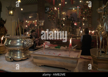 dh Man Mo Temple SHEUNG WAN HONG KONG Chinese women burning joss sticks urn incense stick burner taoist china Stock Photo