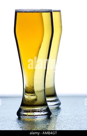 Two Ice Cold Beer Glasses with Condensed Moisture on Reflective Surface with Copy Space Stock Photo