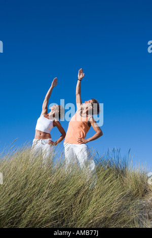 couple doing exercise on the beach Stock Photo