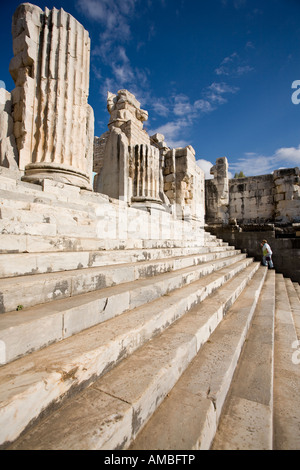 Temple Steps at Didymia An overweight tourist climbs up the steep steps of the temple in the ancient Greek ruins of Didyma Stock Photo