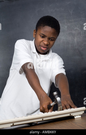 young boy breaking computer keyboard with a hammer Stock Photo - Alamy