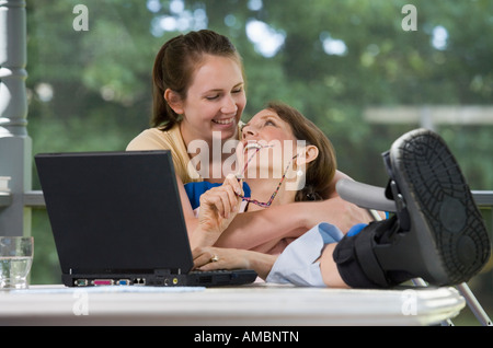 Young woman hugging her mother with foot injury Stock Photo