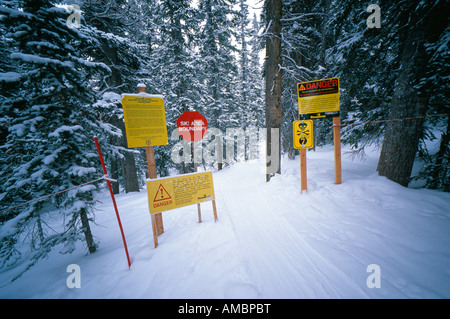 Warning signs at backcountry access gate where ski trail leaves the ski area boundary Steamboat Springs Colorado USA Stock Photo