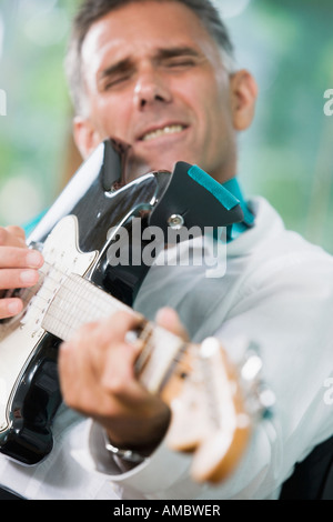 Close-up of a mid adult man playing an electric guitar Stock Photo