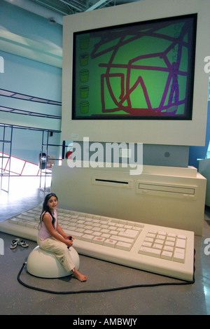 A girl playing with a giant computer, Childrens City, Dubai, UAE Stock Photo