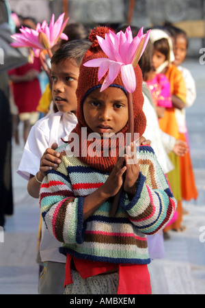 India, Bodhgaya: young buddhist children with lotus flowers visiting the Mahabodhi temple site Stock Photo