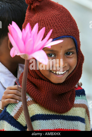 India, Bodhgaya: young buddhist boy with lotus flowers visiting the Mahabodhi temple site Stock Photo