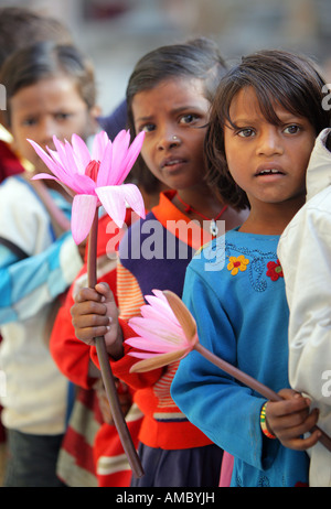 India, Bodhgaya: young buddhist pilgrims with lotus flowers visiting the Mahabodhi temple site Stock Photo