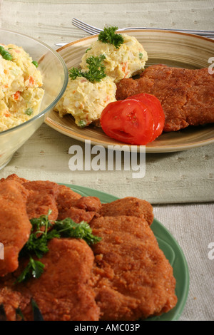 Breaded fried pork chops chop with potato salad with mayonnaise on a plate table cutlets and vegetable food nobody overhead vertical hi-res Stock Photo