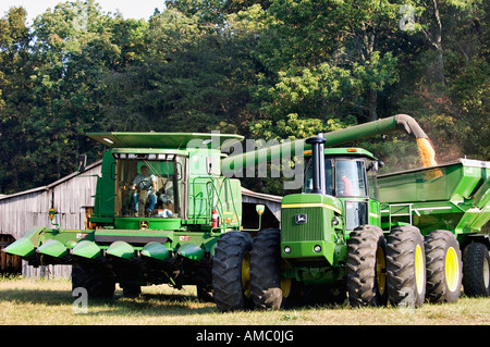 Farmer Transferring Harvested Corn from John Deere Combine to Trailer Behind Large Tractor Harrison County Indiana Stock Photo
