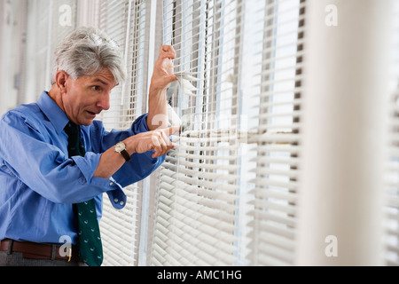 A business man looking out from a window. Stock Photo