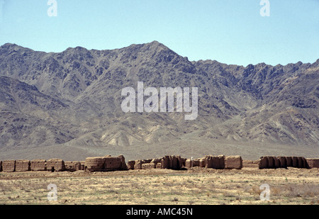 Remote medieval mud village in the Dasht e Lut desert, Iran, with a backdrop of the Elborz Mountains Stock Photo